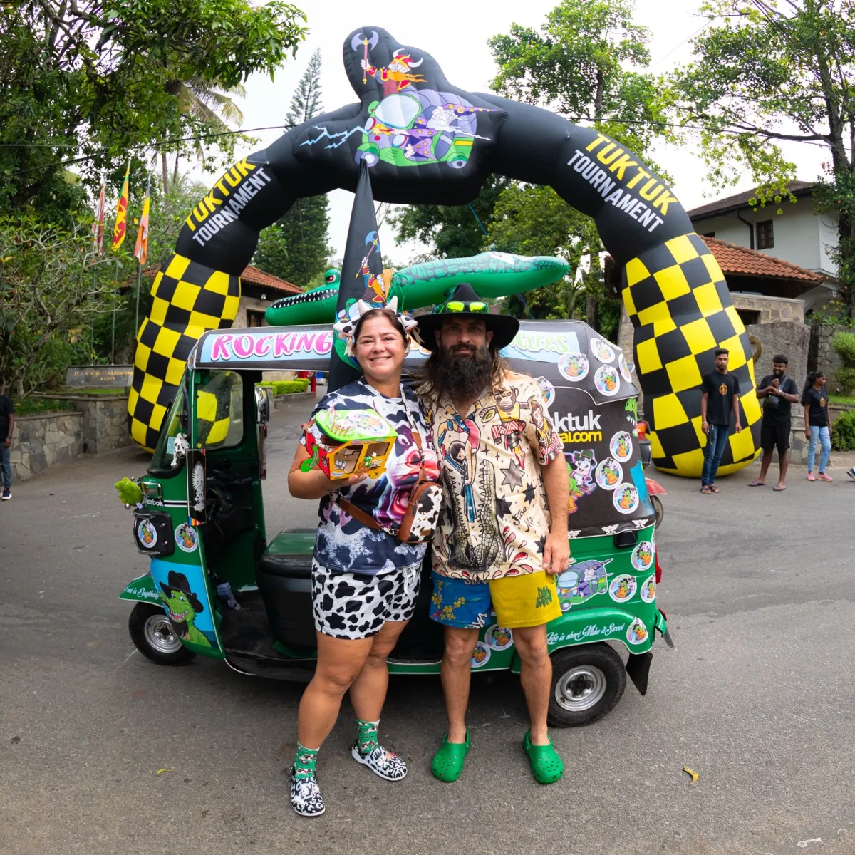 Couple in wild outfits with their decorated tuktuk